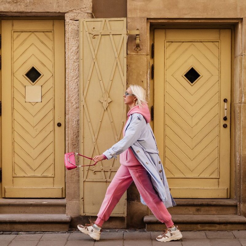 Ragazza cammina sneakers borsa outfit rosa