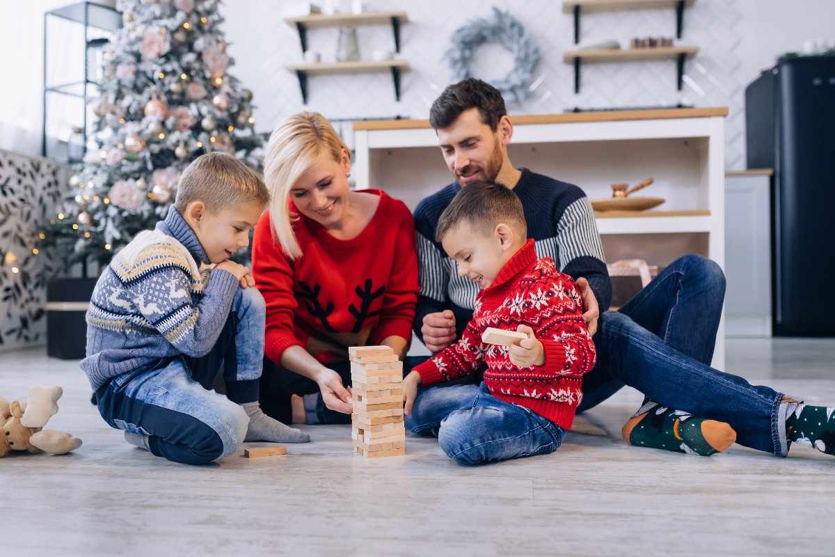 Famiglia con maglioni natalizi che gioca insieme