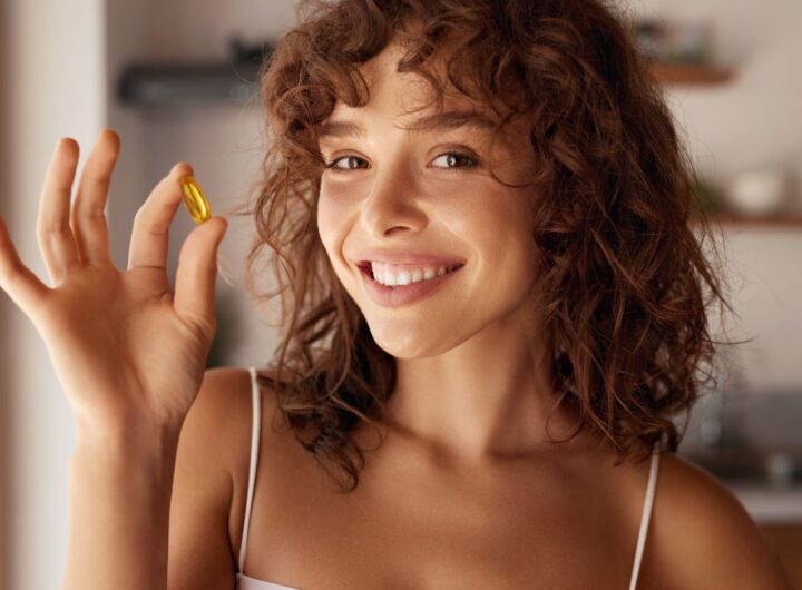 Ragazza che mostra una pillola di vitamine integratore alimentare